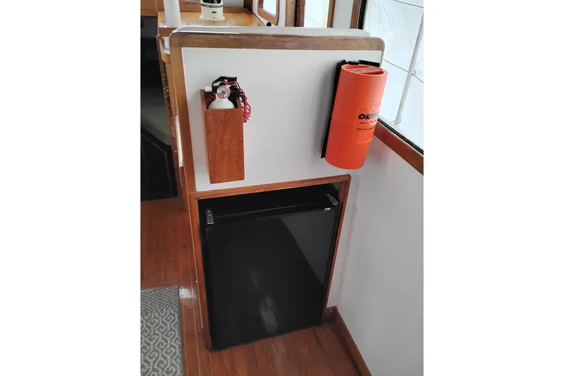 Slide: The Image of 1979 Transpac Eagle 36 Trawler interior with fridge, fire extinguisher, and safety equipment. - 28