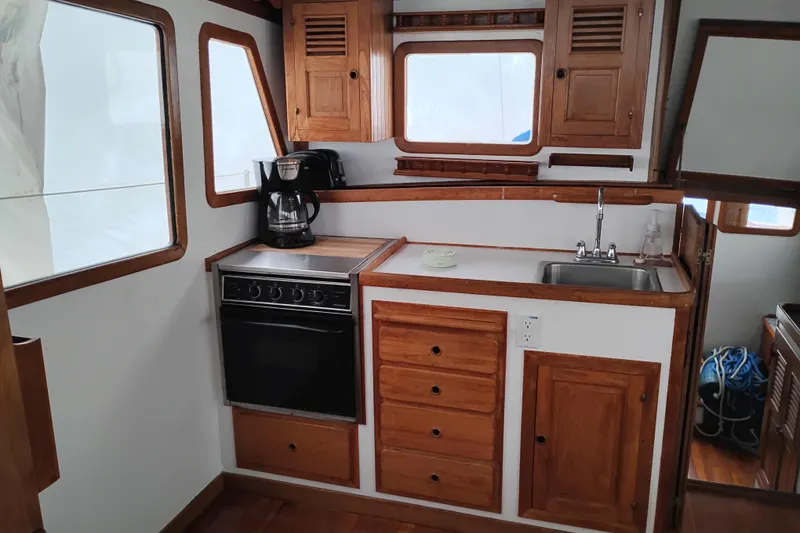Slide: The Image of 1979 Transpac Eagle 36 Trawler kitchen with wooden cabinets, stove, and sink. - 29
