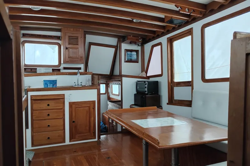Slide: The Image of 1979 Transpac Eagle 36 Trawler interior with wooden cabinetry and dining area. - 33