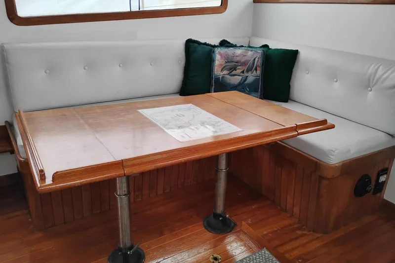 Slide: The Image of 1979 Transpac Eagle 36 Trawler interior with wooden table and cushioned seating. - 35
