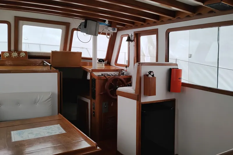 Slide: The Image of Interior of 1979 Transpac Eagle 36 Trawler with wooden helm and seating area. - 37