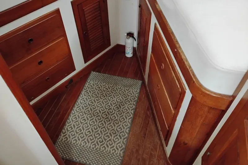 Slide: The Image of 1979 Transpac Eagle 36 Trawler interior with wooden cabinets and patterned rug. - 39