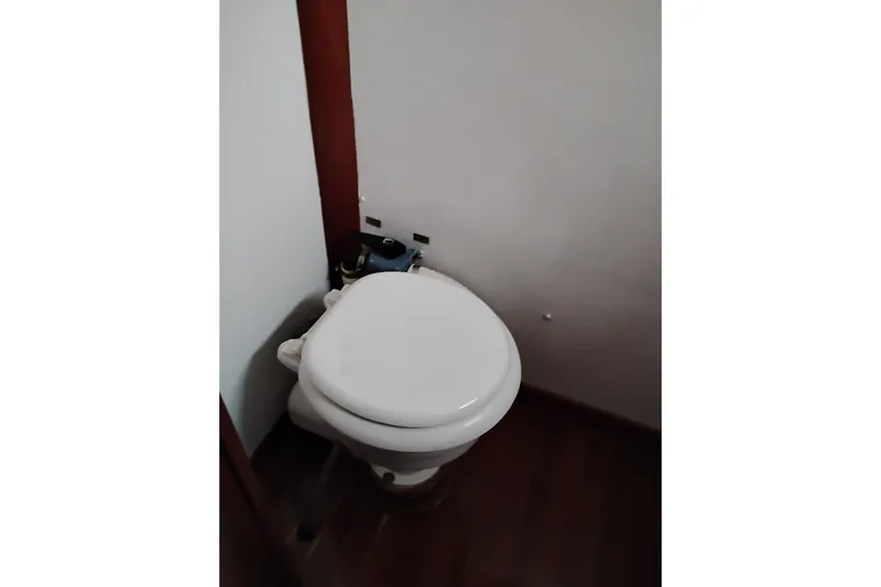 Slide: The Image of 1979 Transpac Eagle 36 Trawler bathroom with white toilet and wooden flooring. - 42