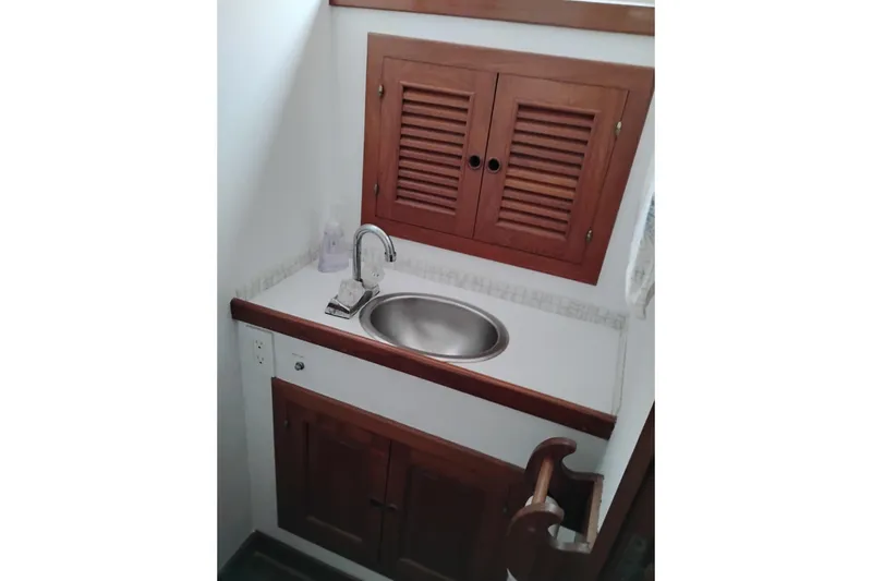 Slide: The Image of 1979 Transpac Eagle 36 Trawler bathroom sink with wooden cabinets and modern faucet. - 43