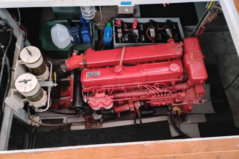 Slide: The Image of Engine compartment of a 1979 Transpac Eagle 36 Trawler with red engine and battery setup. - 45