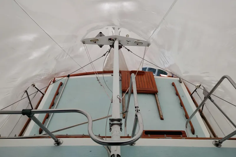 Slide: The Image of 1979 Transpac Eagle 36 Trawler deck under protective cover, showcasing mast and wooden details. - 5