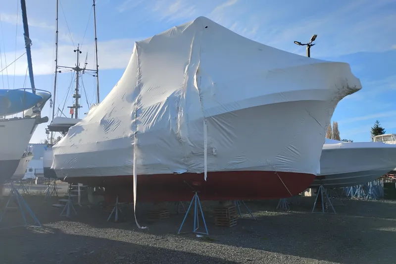 Slide: The Image of 1979 Custom Eagle 36 Trawler covered in protective wrap, docked on land. - 57