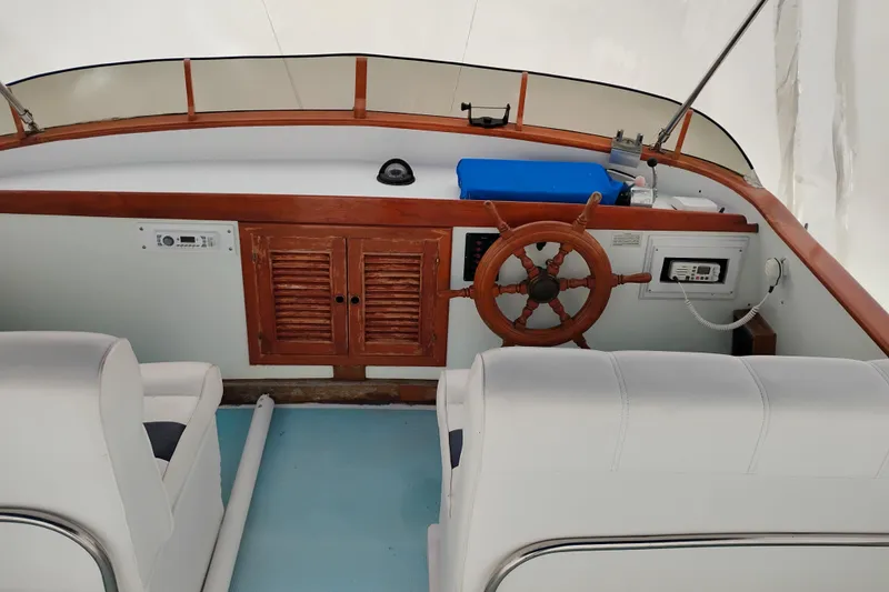 Slide: The Image of 1979 Transpac Eagle 36 Trawler helm with wooden wheel and white seating. - 8
