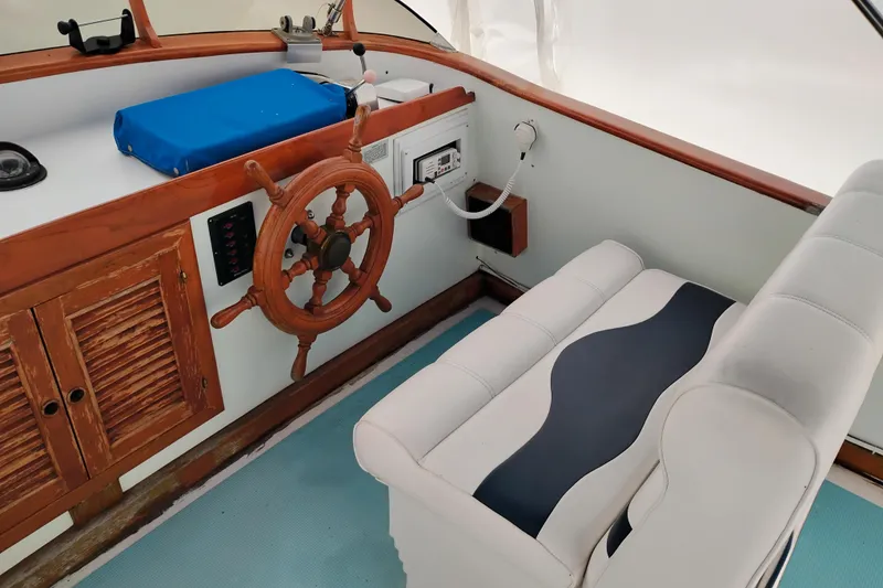 Slide: The Image of 1979 Transpac Eagle 36 Trawler helm with wooden wheel and cushioned seating. - 9