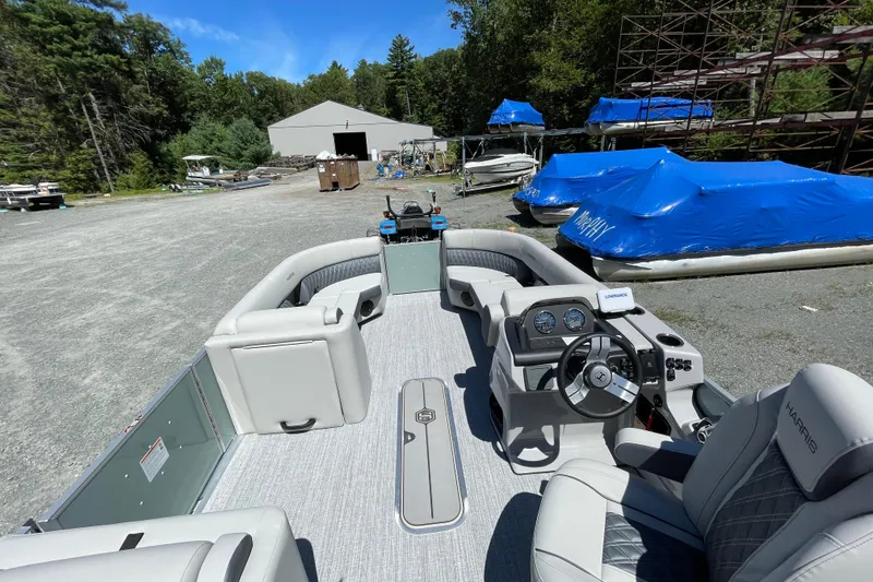 Slide: The Image of 2026 Harris Cruiser 230 pontoon boat interior with steering wheel, docked outdoors. - 4
