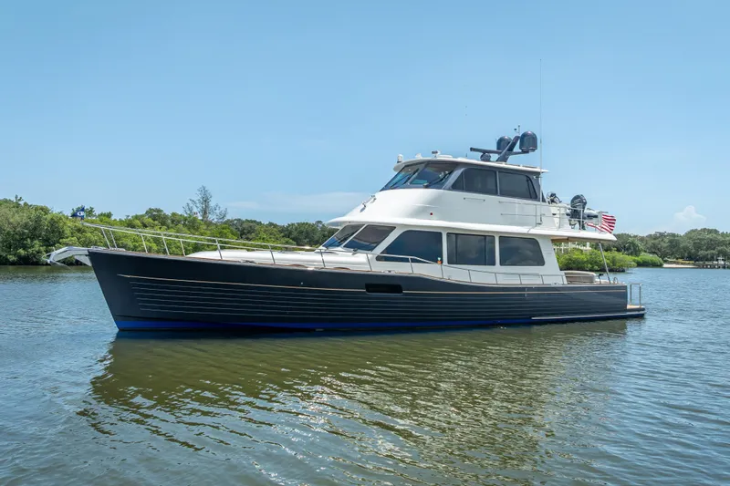 The Image of 2022 Grand Banks GB60 Skylounge yacht cruising on a scenic waterway. - 0