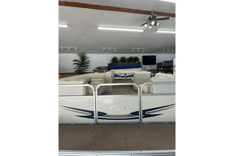 Slide: The Image of 2005 Manitou 22 Oasis pontoon boat with beige seating in a showroom. - 2