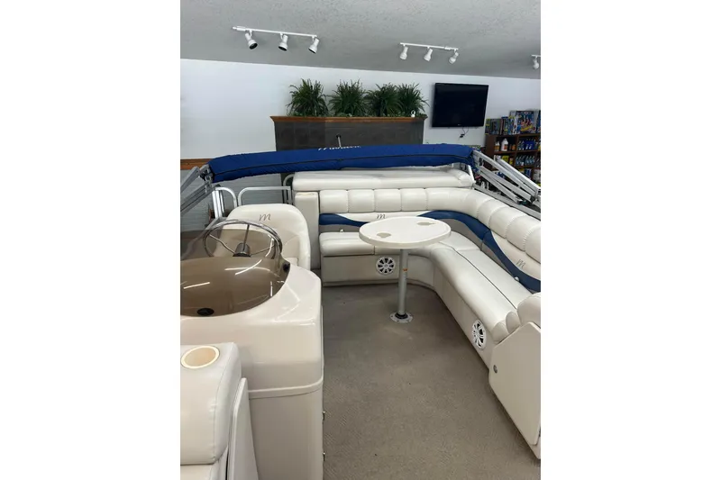 Slide: The Image of 2005 Manitou 22 Oasis pontoon boat interior with white seating and table. - 4