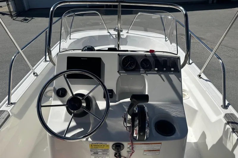 Slide: The Image of 2019 Boston Whaler 150 Montauk boat console with steering wheel and controls. - 2