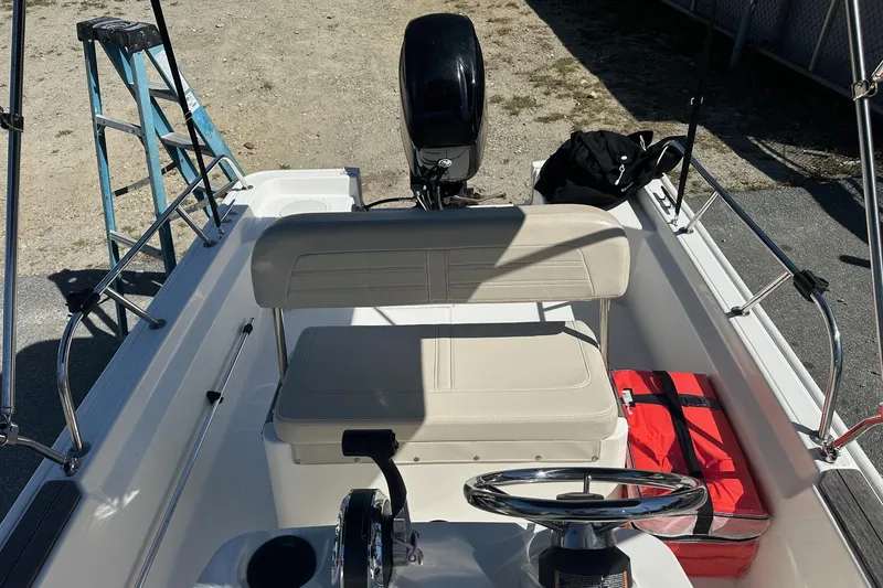 Slide: The Image of 2019 Boston Whaler 150 Montauk boat interior with steering wheel and seating. - 3