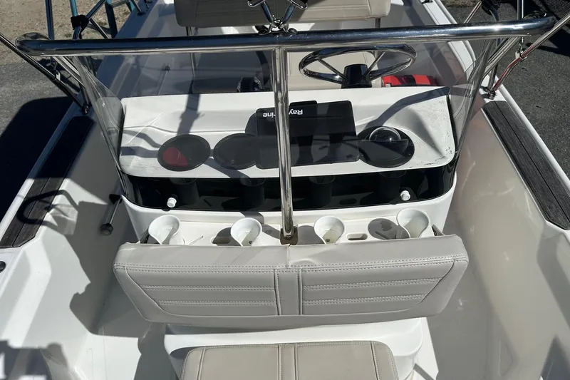 Slide: The Image of 2019 Boston Whaler 150 Montauk boat interior with steering wheel and cup holders. - 6