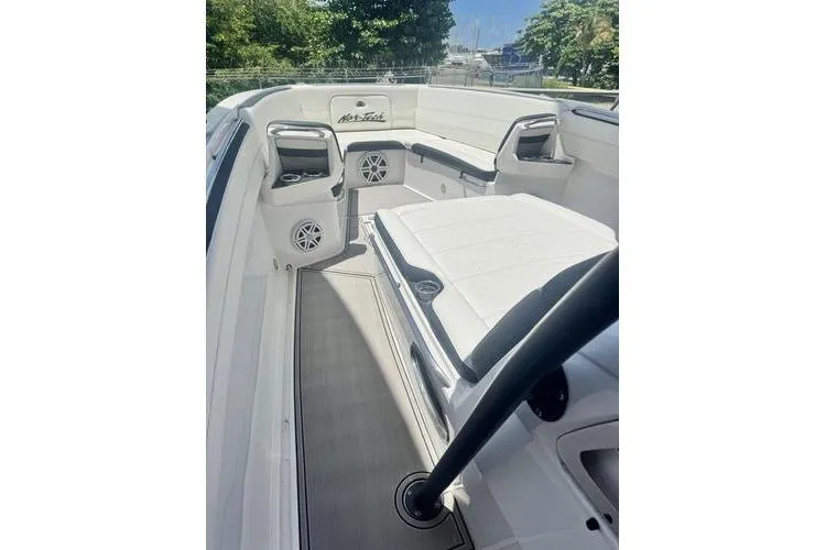 Slide: The Image of 2019 Nor-Teck 390 Sport Center Console boat interior with white seating and speakers. - 14