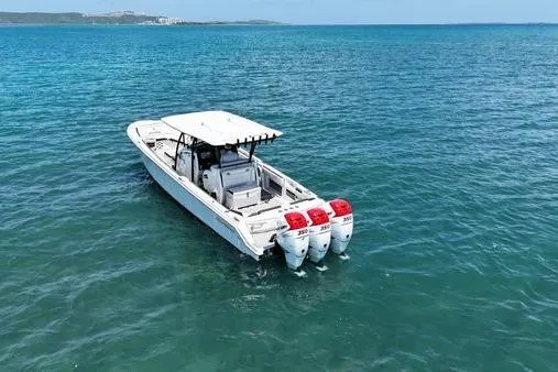 Slide: The Image of 2019 Nor-Teck 390 Sport Center Console boat with triple engines on open water. - 3