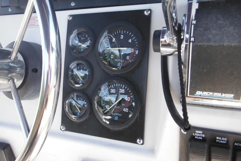 Slide: The Image of Dashboard of a 1996 Boston Whaler Outrage 17 boat with gauges and controls. - 12