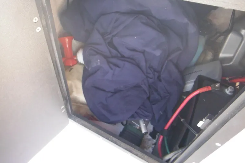 Slide: The Image of Storage compartment of a 1996 Boston Whaler Outrage 17 with cables and a red horn. - 14
