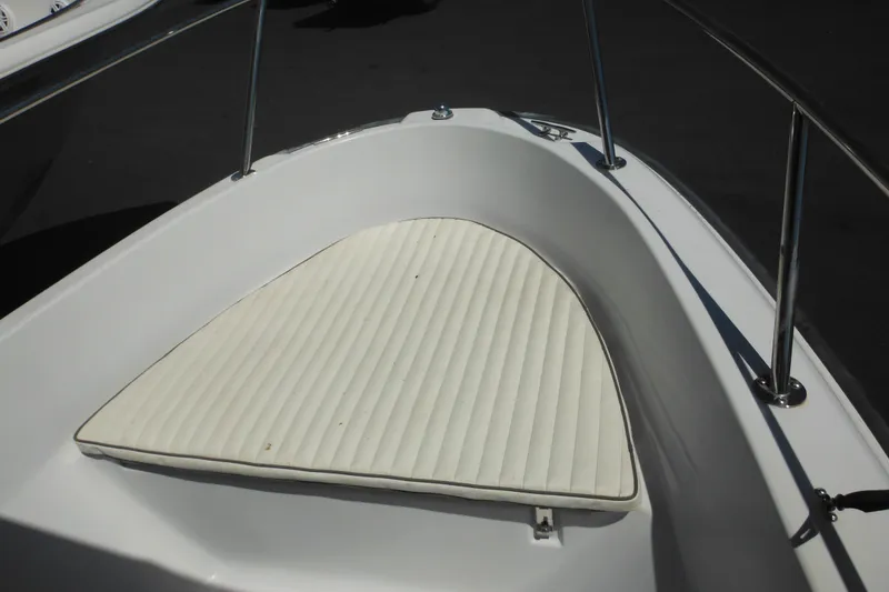 Slide: The Image of 1996 Boston Whaler Outrage 17 boat bow with cushioned seating and stainless steel railing. - 17