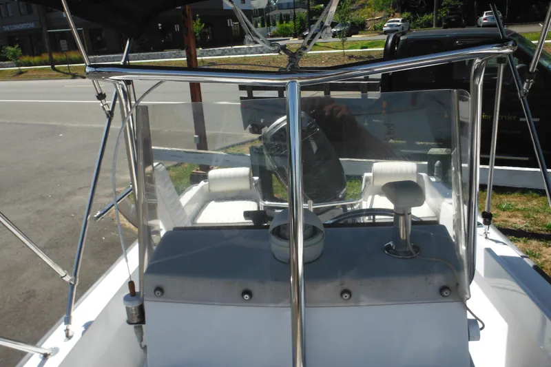 Slide: The Image of 1996 Boston Whaler Outrage 17 boat console with steering wheel and seating. - 21