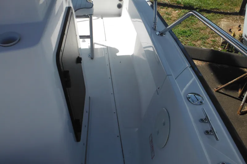 Slide: The Image of 1996 Boston Whaler Outrage 17 interior, featuring sleek white deck and stainless steel fittings. - 23