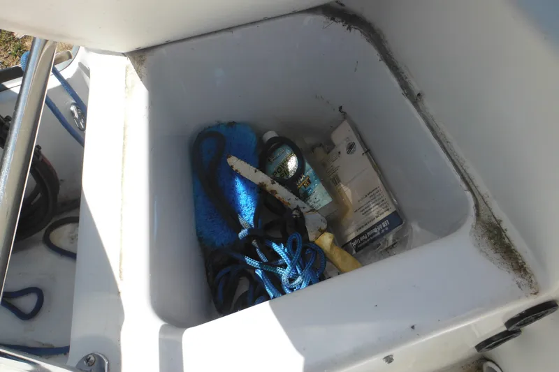Slide: The Image of Storage compartment of a 1996 Boston Whaler Outrage 17 with ropes and cleaning supplies. - 29
