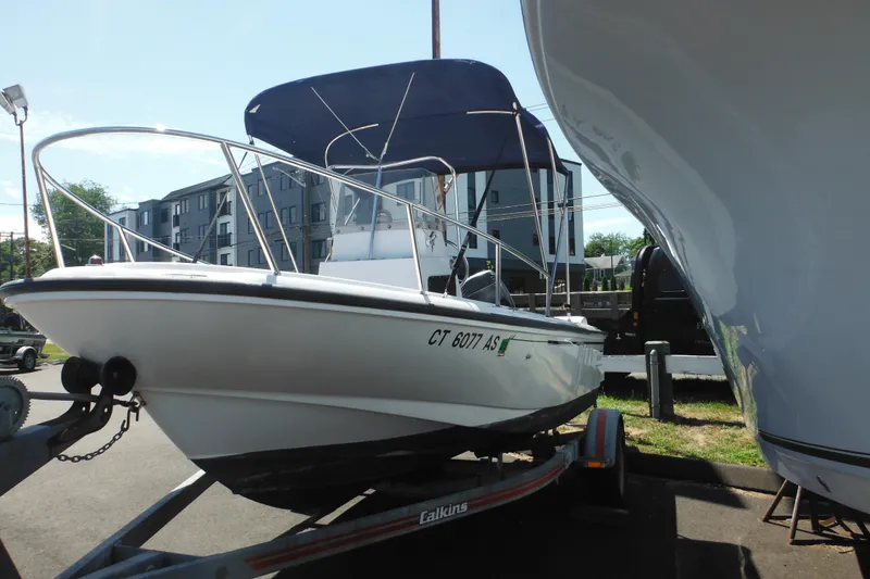 Slide: The Image of 1996 Boston Whaler Outrage 17 boat on trailer with blue canopy. - 3