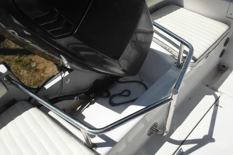 Slide: The Image of 1996 Boston Whaler Outrage 17 boat interior with seating and engine details. - 31