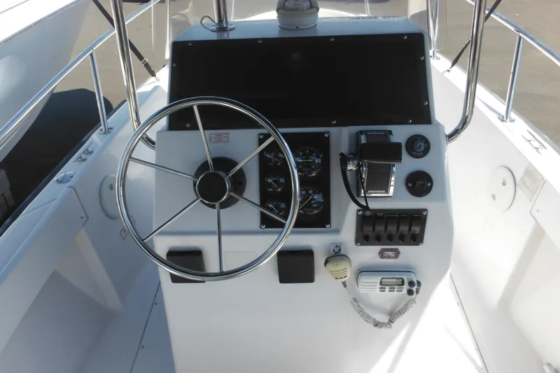 Slide: The Image of 1996 Boston Whaler Outrage 17 boat console with steering wheel and controls. - 8