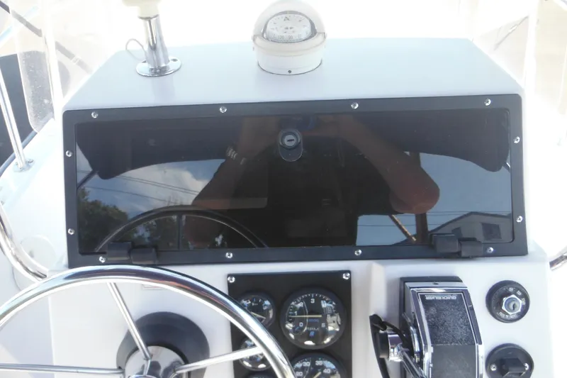 Slide: The Image of 1996 Boston Whaler Outrage 17 dashboard with steering wheel and gauges. - 9