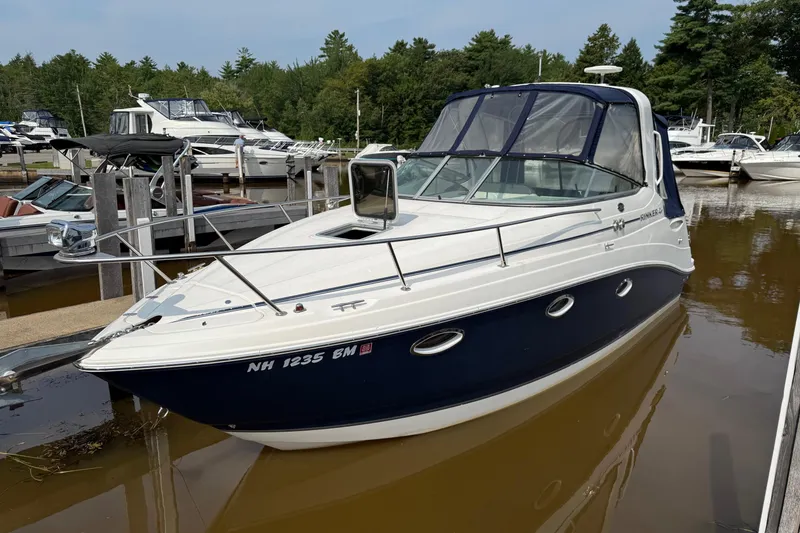 The Image of 2008 Rinker 260 Express Cruiser docked in a marina, surrounded by other boats. - 0
