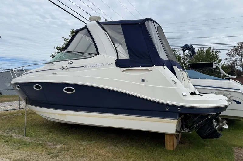 Slide: The Image of 2008 Rinker 260 Express Cruiser boat with blue and white exterior, parked on grass. - 10