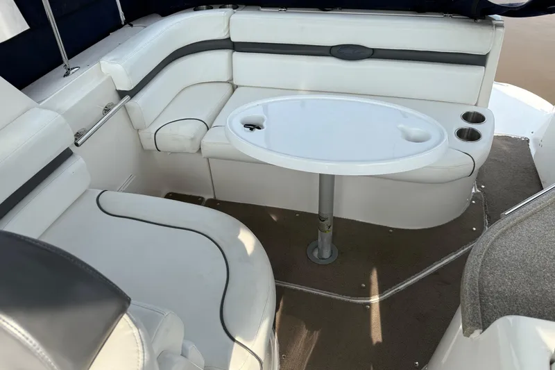 Slide: The Image of 2008 Rinker 260 Express Cruiser interior with white seating and oval table. - 3