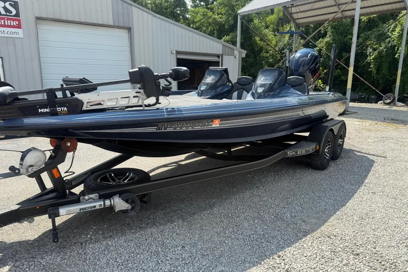 Slide: The Image of 2020 Skeeter ZX225 bass boat on trailer, parked outside a metal building. - 3