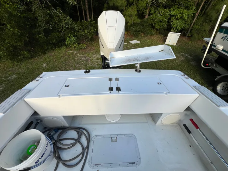 Slide: The Image of 1998 Dusky 256 boat deck with storage, motor, and fishing equipment. - 10