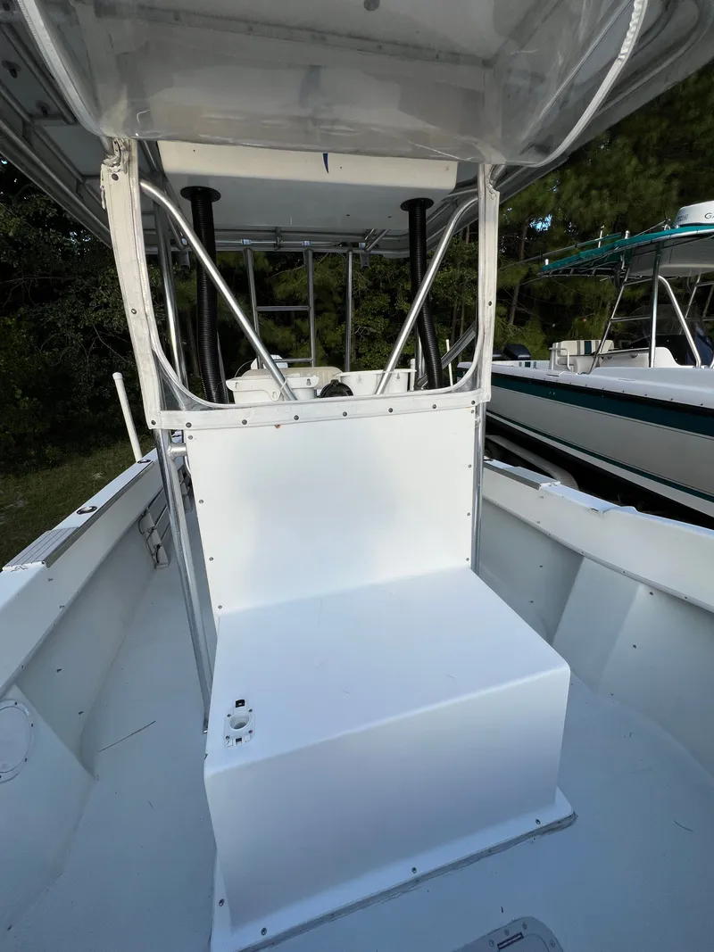 Slide: The Image of 1998 Dusky 256 boat interior with white seating and metal framework. - 12