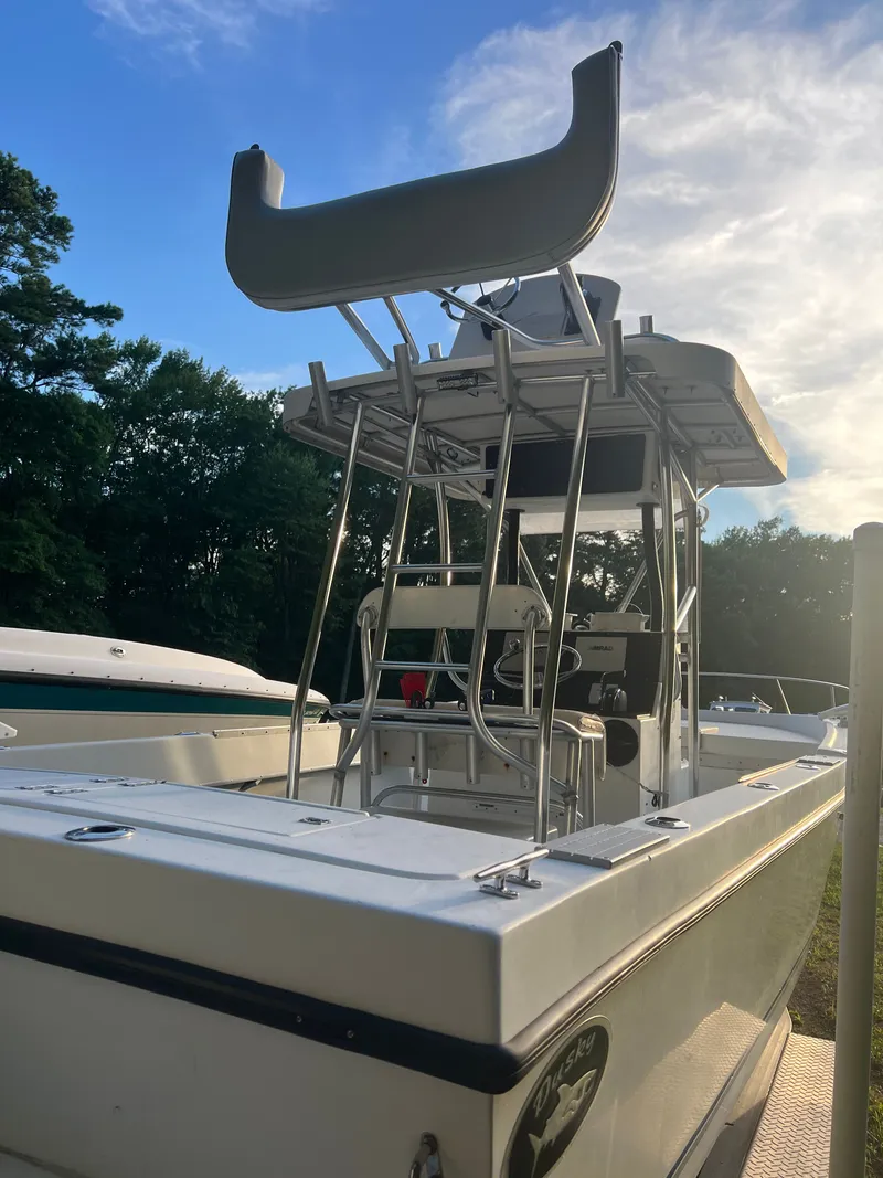 Slide: The Image of 1998 Dusky 256 boat with tower, docked under a clear sky. - 7