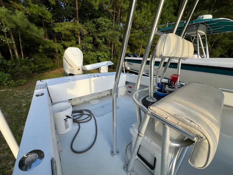 Slide: The Image of 1998 Dusky 256 boat interior with seating, fishing gear, and Mercury outboard motor. - 9