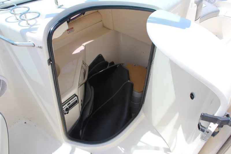 Slide: The Image of 2006 Sea Ray 270 Sundeck storage compartment with black cover and interior details. - 19