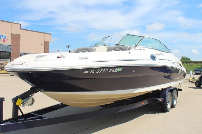 Slide: The Image of 2006 Sea Ray 270 Sundeck boat on trailer, parked outdoors under blue sky. - 3