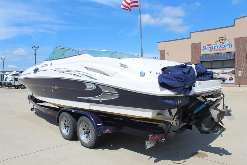 Slide: The Image of 2006 Sea Ray 270 Sundeck boat on trailer at dealership, clear sky background. - 5