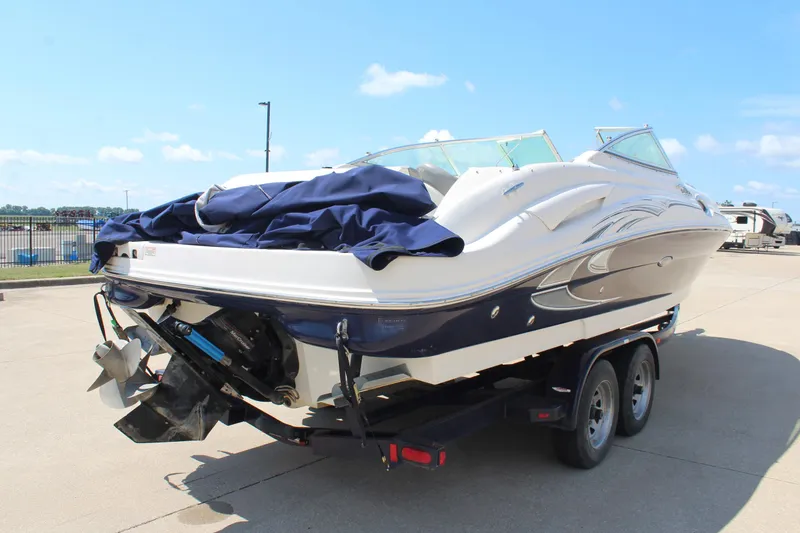 Slide: The Image of 2006 Sea Ray 270 Sundeck boat on trailer, parked outdoors under clear sky. - 7