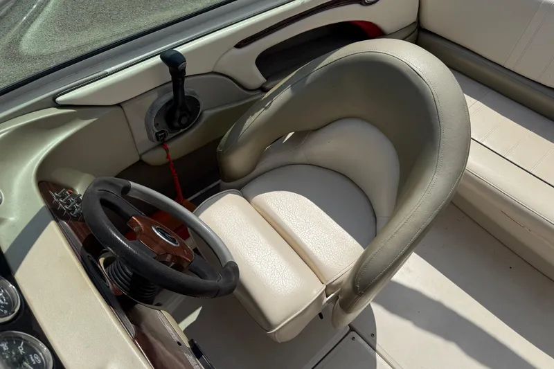 Slide: The Image of 2004 Sea Ray 200 Select boat interior with steering wheel and beige seating. - 14