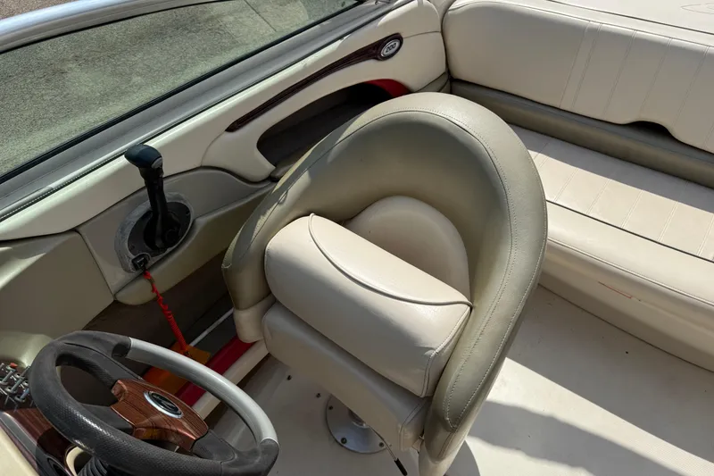 Slide: The Image of 2004 Sea Ray 200 Select boat interior with beige seating and steering wheel. - 15