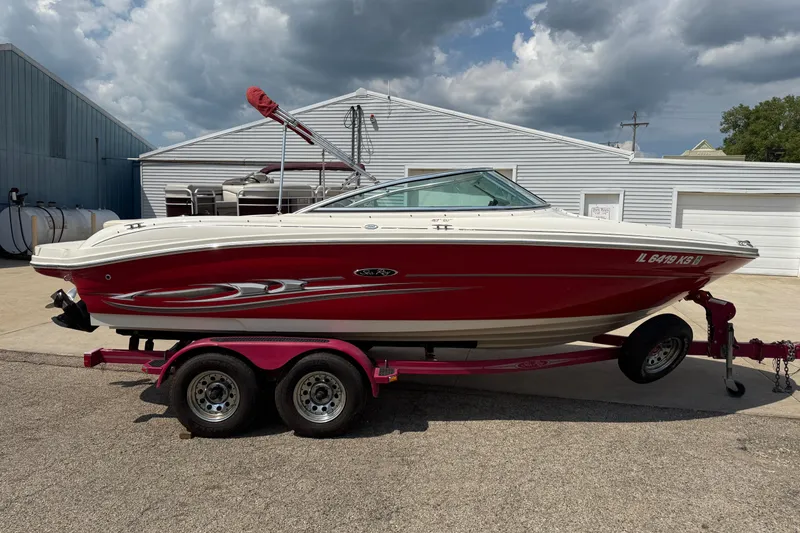 Slide: The Image of 2004 Sea Ray 200 Select boat on trailer, parked outdoors under cloudy sky. - 4