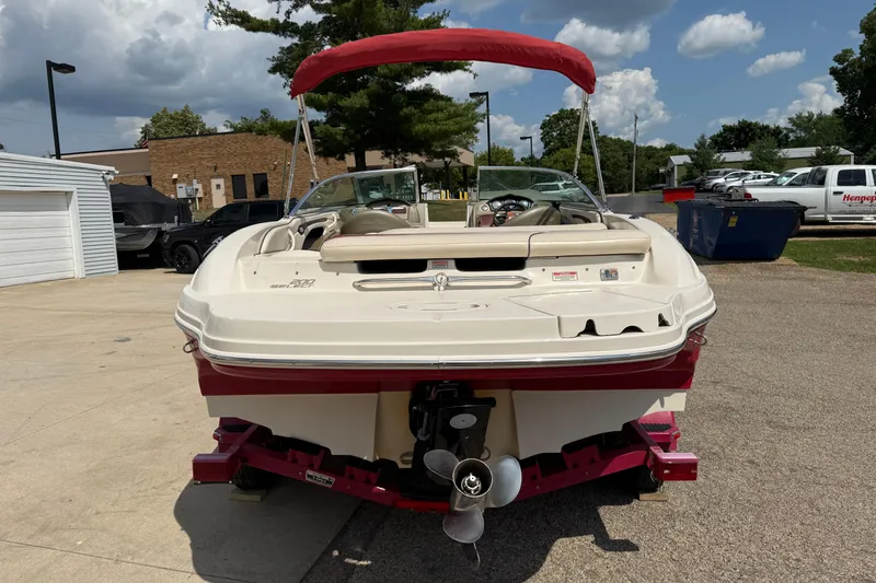 Slide: The Image of 2004 Sea Ray 200 Select boat with red canopy, parked outdoors on a sunny day. - 6