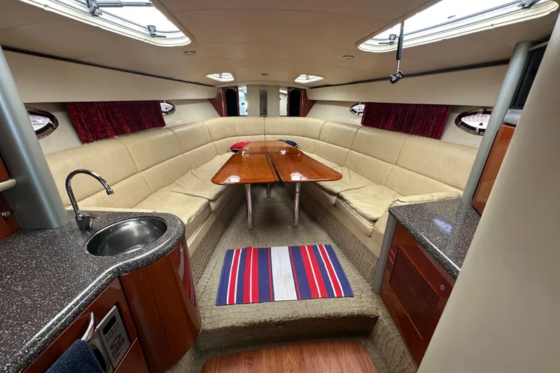 Slide: The Image of 2007 Formula 400 Super Sport yacht interior with beige seating, wooden table, and kitchenette. - 31