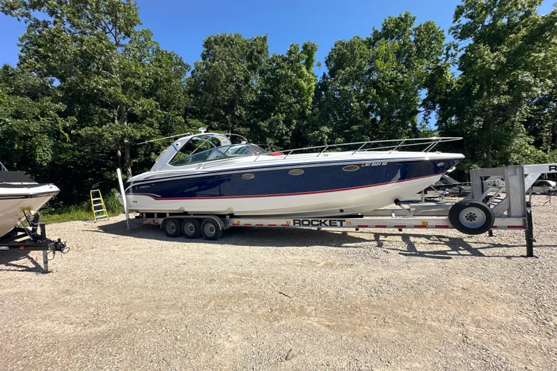 Slide: The Image of 2007 Formula 400 Super Sport boat on trailer, surrounded by trees and gravel. - 4